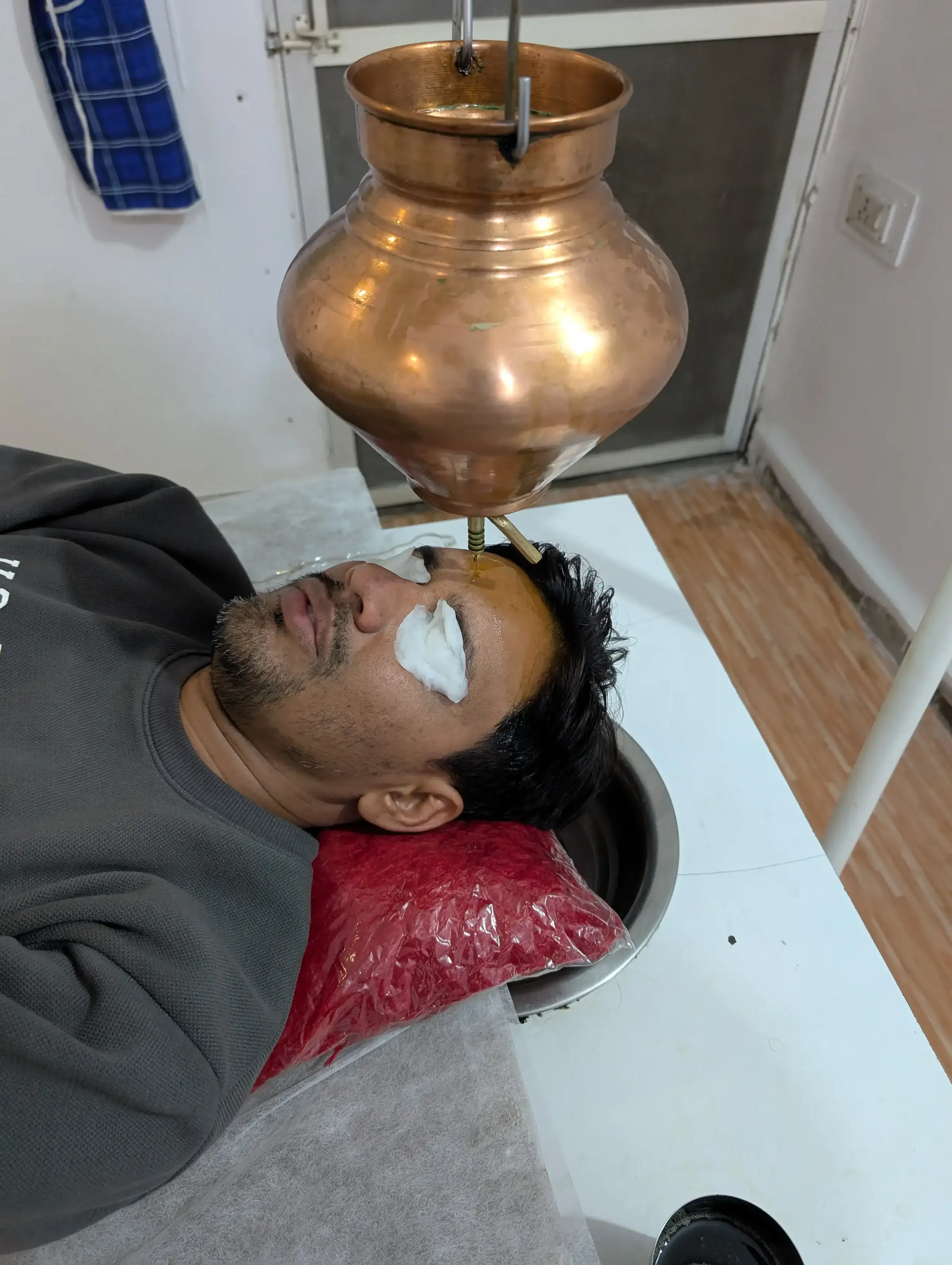 Shirodhara therapy at Ayurveda Gokulam Clinic, Indore — warm oil poured in a steady stream